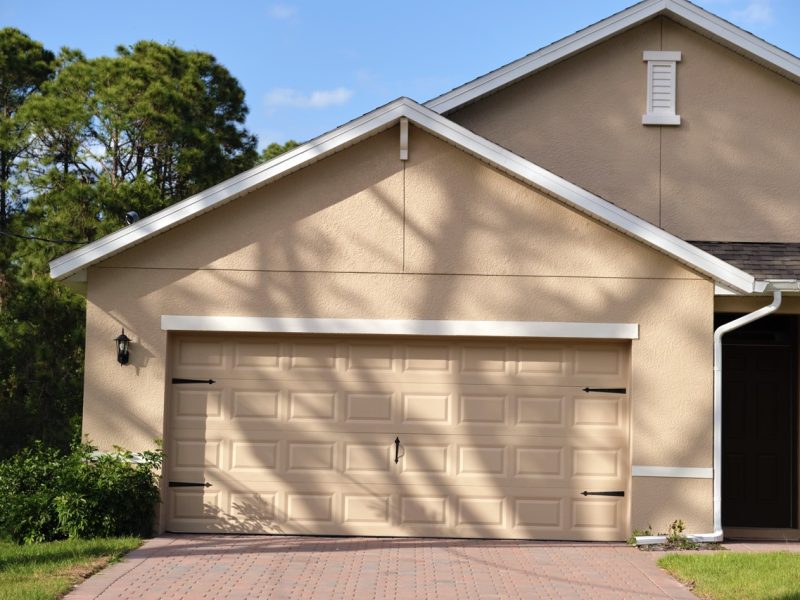 Wide garage double door and concrete driveway of new modern american house.
